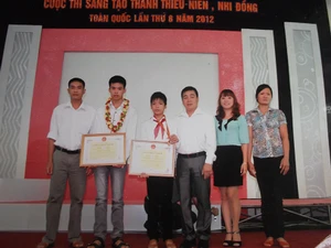 Hoàng Đình Hoành (quàng khăn đỏ) trong buổi lễ trao Giải thưởng Cuộc thi sáng tạo thanh, thiếu niên, nhi đồng toàn quốc lần thứ 8 năm 2012. Nguồn: yenbai.gov.vn)
